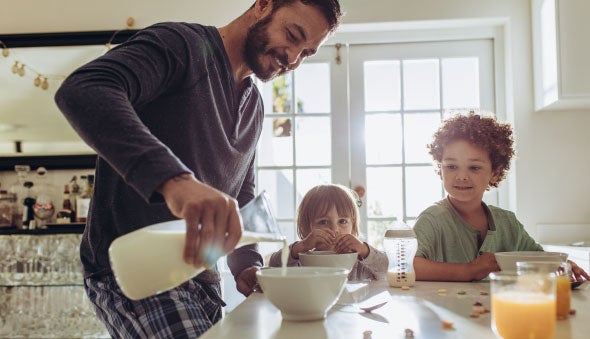 papa sirviendo leche a sus hijos