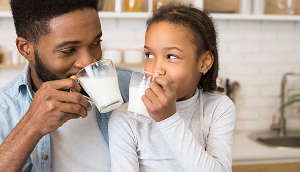 Papá e hija tomando leche