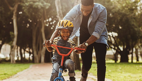 Papá enseñando a su hijo a montar bicicleta