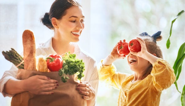 Mamá e hija felices con su canasta familiar saludable