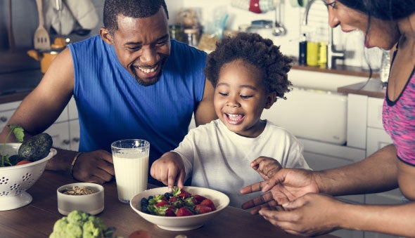 Familia divirtiéndose mientras come fresas con leche