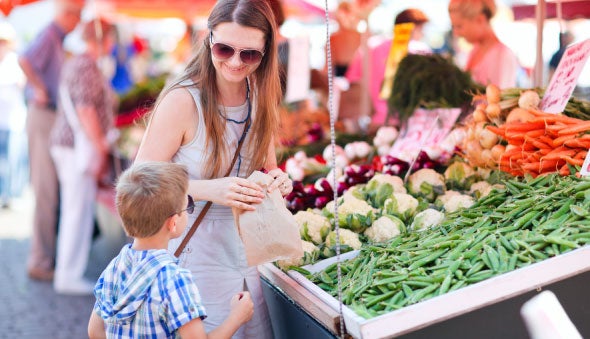 Madre e hijo en el mercado seleccionando vegetales