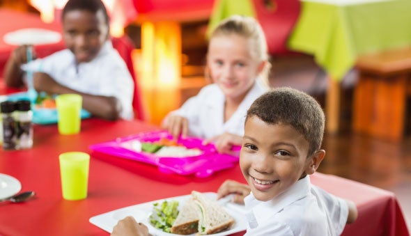 Grupo de niños en edad escolar comiendo su lonchera