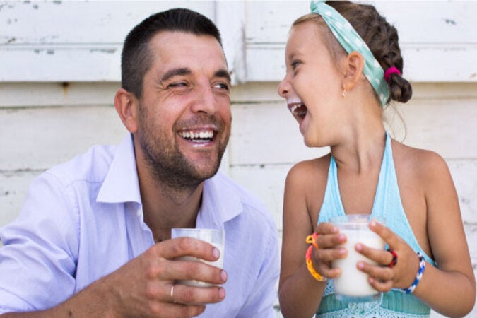 Papa e hija tomando felices lacteo 