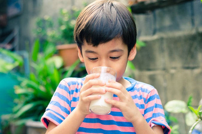 Niño tomando leche fuera de casa