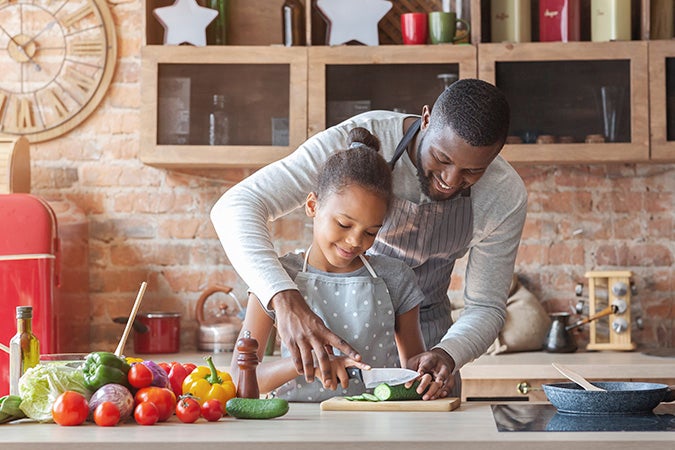 Papa e hija preparando verduras 