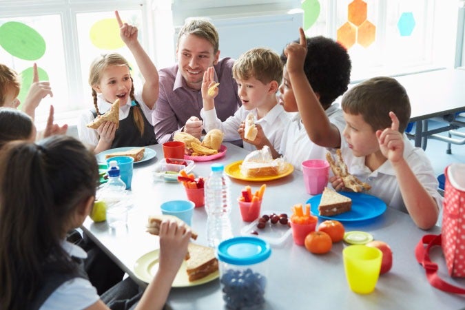 Niños en edad escolar comiendo la lonchera juntos