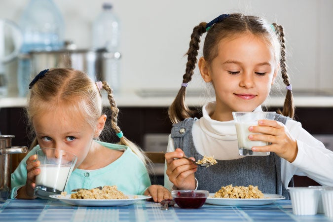 Dos niñas desayunando en casa