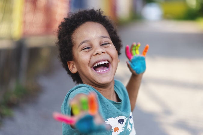 Niño feliz con sus manos pintadas
